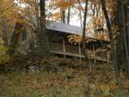 Cozy cabin in the trees with rocking-chair front porch.