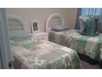 white wicker twin beds with matresses sheets comforters night stand and mirror